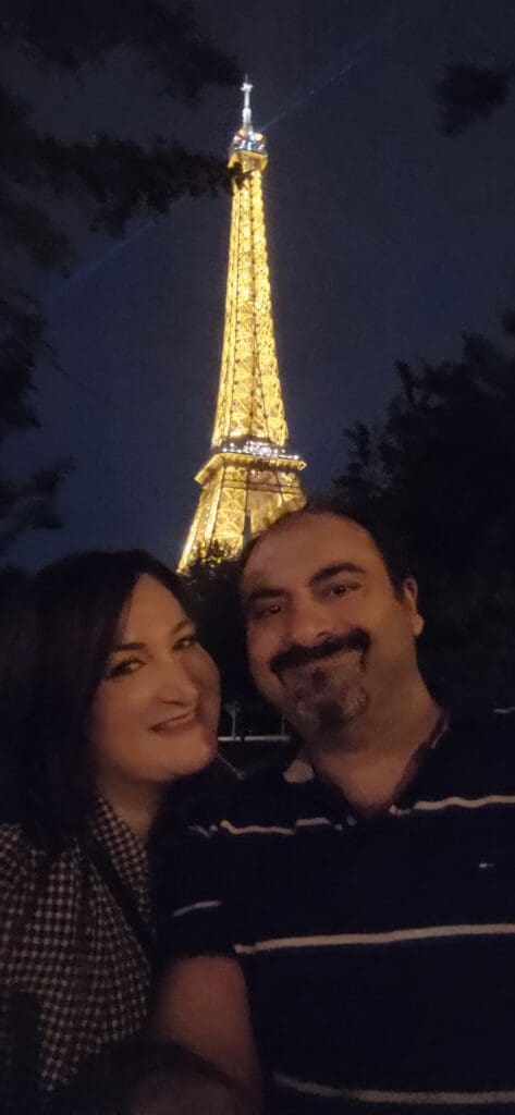 Photo of Mary, founder of Marycuterie, and her husband standing in front of the Eiffel Tower in Paris, France